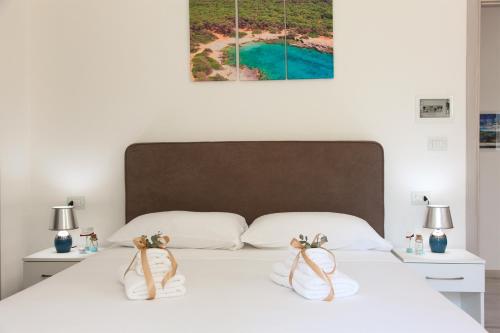 a bedroom with a white bed with two white night stands at Rest House The Village in Nardò