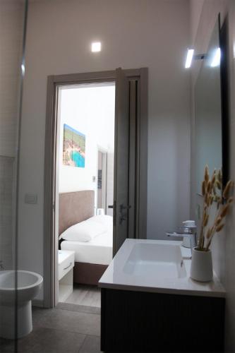 a bathroom with a tub and a sink and a bed at Rest House The Village in Nardò