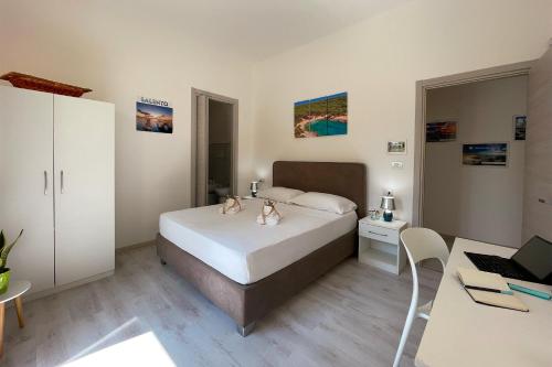 a bedroom with a bed and a desk with a laptop at Rest House The Village in Nardò