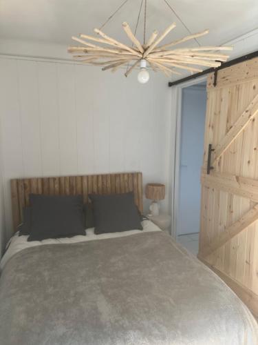 une chambre avec un grand lit et un lustre dans l'établissement appartement meuble vue sur le port, à Canet