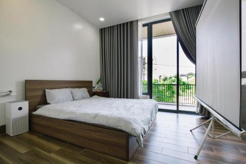 a bedroom with a bed and a balcony at Ana La Vie Hue in Thôn Dương Xuân Hạ