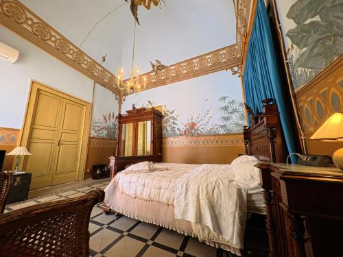 a bedroom with a bed and a painting on the wall at Palazzo Framarino dei Malatesta - Noble Floor - XIV Century in Giovinazzo
