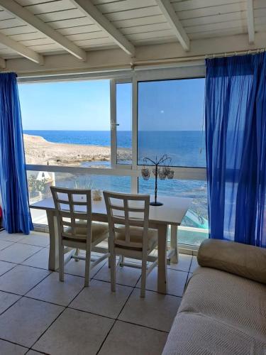a dining room with a table and chairs and the ocean at Lodges Tenerife in La Mareta