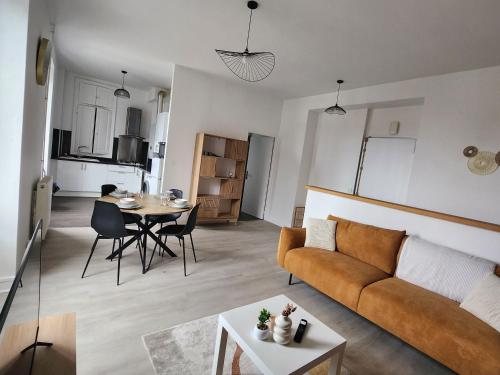 un salon avec un canapé et une table dans l'établissement Le Nid ensoleillé, à Jurançon