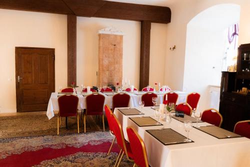a room with tables and red chairs and a room with at Ēdoles Pils in Ēdole