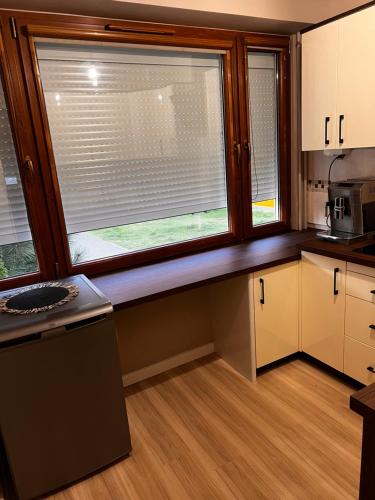a kitchen with a large window in the middle at Mokka Apartament Konin in Konin