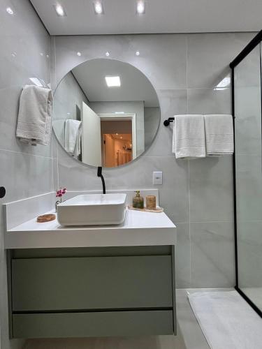 a bathroom with a sink and a mirror at Summit Flat Exclusivo Proximo ao center Vale shopping in São José dos Campos