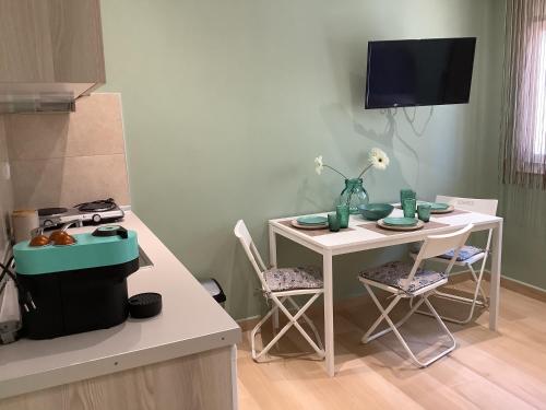a kitchen with a table and a small table with chairs at N G Luxury Apartments at Nea Kallikrateia No 2 in Nea Kalikratia