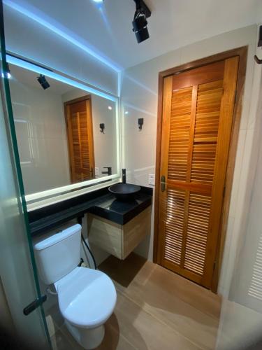 Un baño con inodoro, lavabo y espejo. en Apartamento Angeleti, en Río de Janeiro