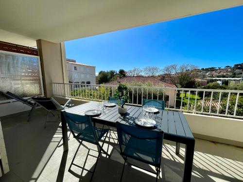 une table et des chaises sur un balcon avec vue dans l'établissement Moderne - Terrasse - Proche plages, à Carqueiranne