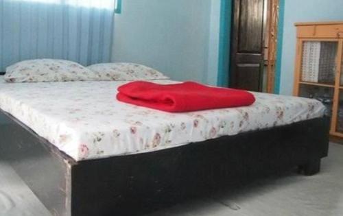 a red blanket sitting on top of a bed at Coastal star Rooms in Honāvar
