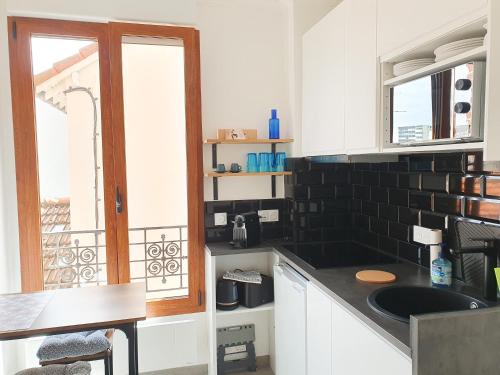 une cuisine avec un évier et une fenêtre dans l'établissement Joli studio en centre-ville à 20 min de Paris, à Vélizy-Villacoublay