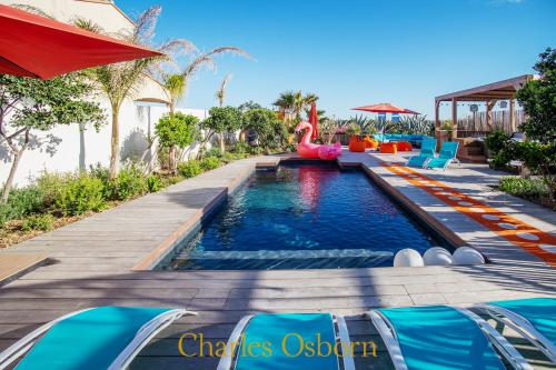 une piscine dans un complexe hôtelier avec un toboggan en forme de flamant rose dans l'établissement Villa Seventy, à Frontignan