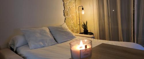 une bougie sur une table à côté d'un lit dans l'établissement Architect's studio with pool, sea view and AC, à Théoule-sur-Mer