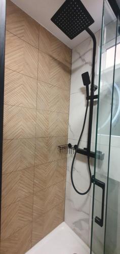 une douche avec un pommeau et une paroi en verre dans l'établissement Architect's studio with pool, sea view and AC, à Théoule-sur-Mer