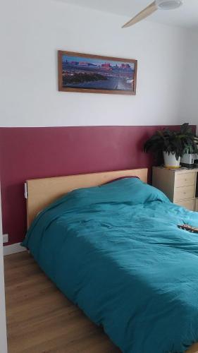 une chambre avec un lit avec une couverture bleue dans l'établissement Appartement Centre Ville SAINT CYR SUR MER, à Saint-Cyr-sur-Mer