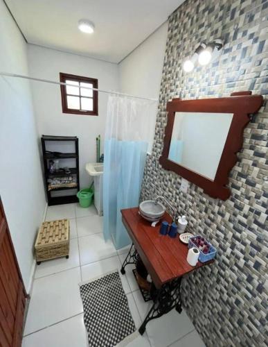 a bathroom with a sink and a mirror on a wall at Chalé Vila do Lago 2 - 5min do Centro de Joa in Joanópolis
