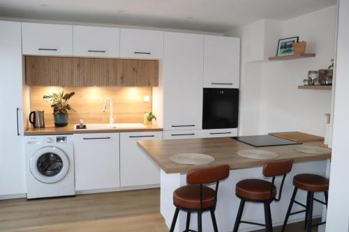 une cuisine avec des armoires blanches et un comptoir en bois dans l'établissement Appartement Centre Ville SAINT CYR SUR MER, à Saint-Cyr-sur-Mer