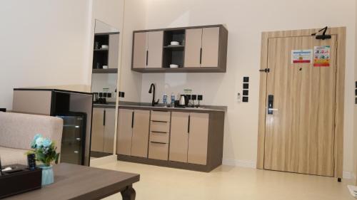 a kitchen with wooden cabinets and a door in a room at The bright View hotel in Al Khafji