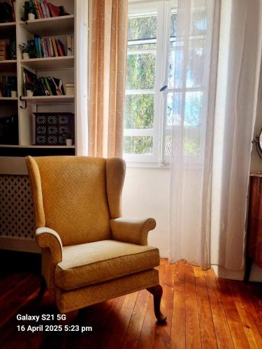 a chair sitting in a room with a window at Maison Maisy in Navarrenx