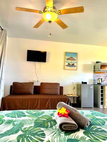 a bedroom with a bed with a ceiling fan at Teahupo'o Lodge - accès mer et vue montagne - canoes gratuits in Vaihi