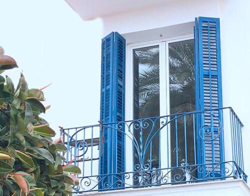 a balcony with blue shutters and a plant at Entire Flat First Beach line - Sea Views - Vilanova i Geltru in Vilanova i la Geltrú