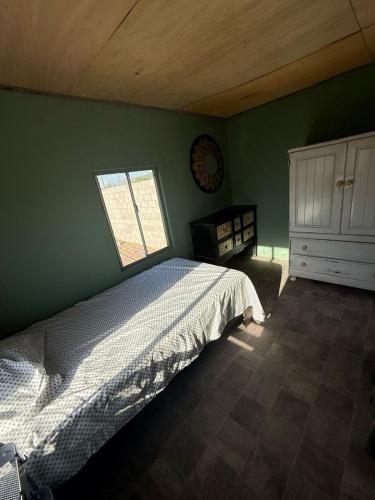 a green bedroom with a bed and a window at Bonito Estudio en una casa mobil in Mexicali
