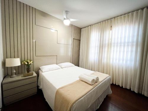 a bedroom with a white bed and a window at Solar Aguilar - Casarão in Diamantina