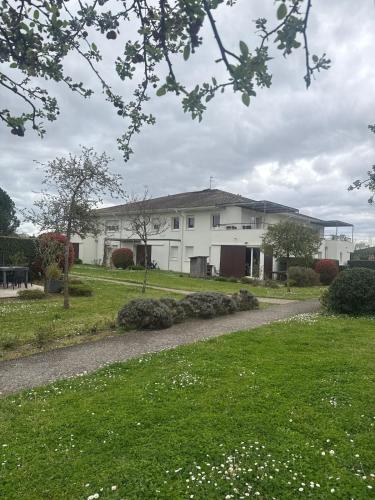 une maison blanche avec une passerelle dans une cour dans l'établissement Appartement T2 proche Bordeaux, à Saint-Loubès