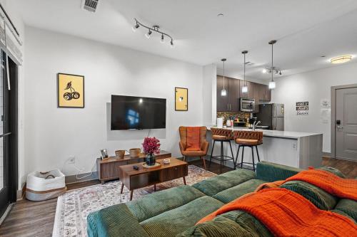 a living room with a green couch and a kitchen at Mid-Century Charm in Midtown Nashville in Nashville