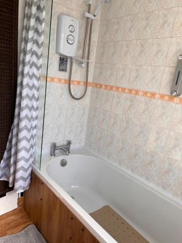 a bath tub in a bathroom with a shower at Gorgeous Full Home in Edinburgh in Edinburgh
