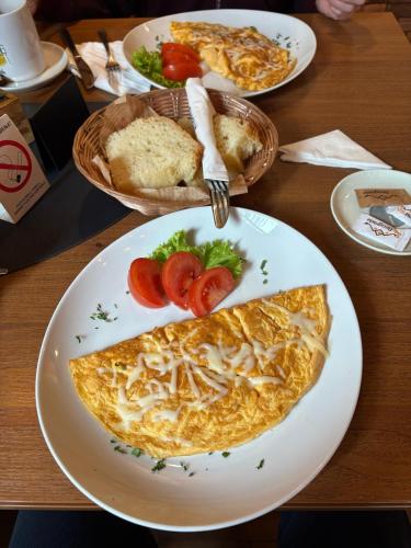 a plate of omelet with tomatoes and bread on a table at VP apartment in Belgrade
