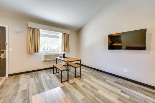a room with a table and a television on a wall at WFH-Friendly Studio Near Lighthouse Beach! in Port Huron