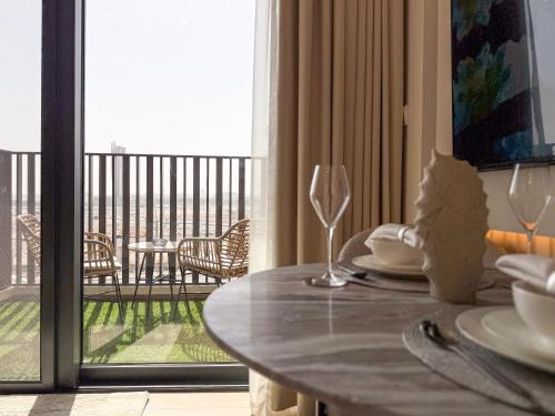 a dining table in a room with a view of a balcony at Modern Chic Studio Apartment, Belgravia Heights 2, JVC Dubai in Dubai