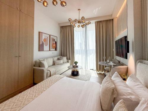 a bedroom with a white bed and a living room at Modern Chic Studio Apartment, Belgravia Heights 2, JVC Dubai in Dubai