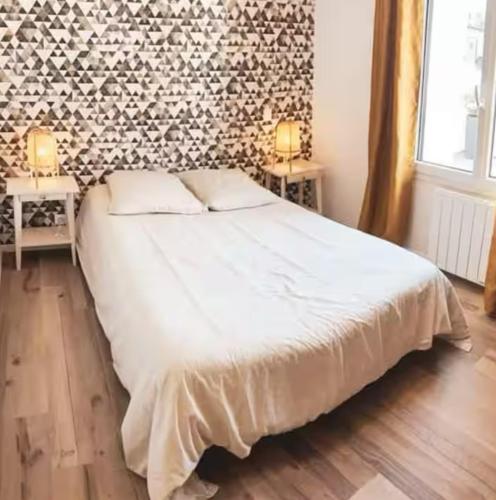 - une chambre avec un lit et 2 tables avec des lampes dans l'établissement Appartement avec grande terrasse, à Pont-de-Buis