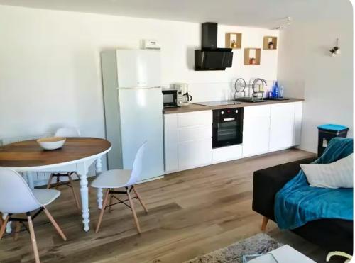un salon avec une table et une cuisine dans l'établissement Appartement avec grande terrasse, à Pont-de-Buis