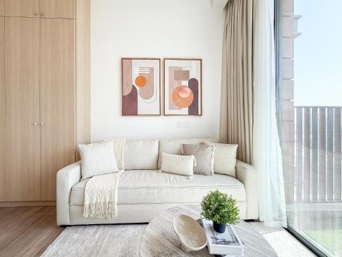 a living room with a couch and a table at Modern Chic Studio Apartment, Belgravia Heights 2, JVC Dubai in Dubai
