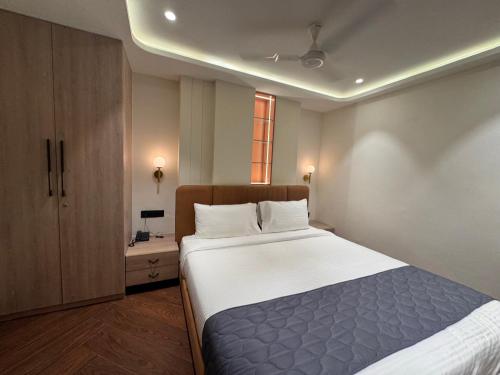 a bedroom with a large bed and a window at Hotel Mumbai House Vijay Nagar Nr Brilliant Convention Center in Indore