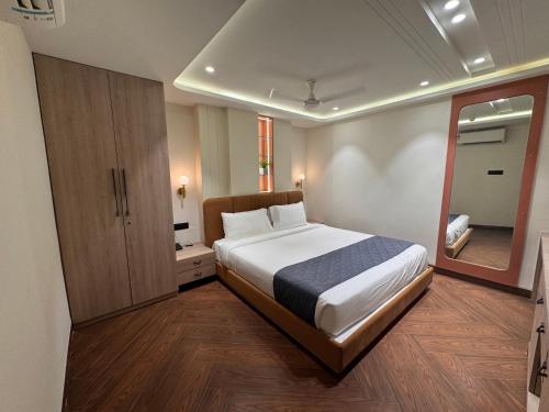 a bedroom with a large bed and a mirror at Hotel Mumbai House Vijay Nagar Nr Brilliant Convention Center in Indore