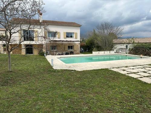 une piscine devant une maison dans l'établissement Appartement T4 à l'étage d'une villa avec piscine et jardin, à Grasse