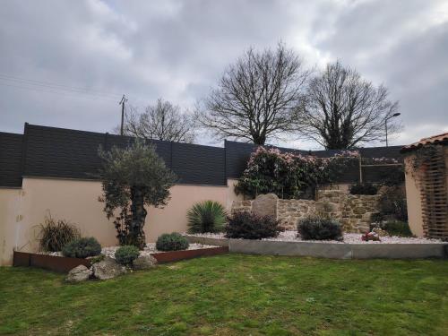 une arrière-cour avec un mur de retenue et un jardin dans l'établissement la ROCHE MOLIVE, à La Verrie