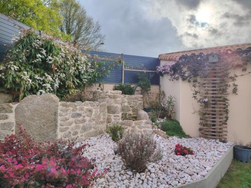 un jardin avec des rochers et des fleurs devant un bâtiment dans l'établissement la ROCHE MOLIVE, à La Verrie