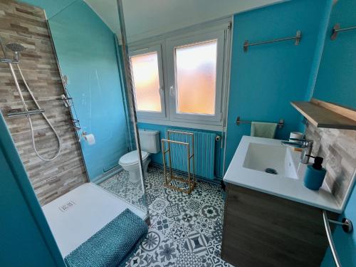 La salle de bains bleue est pourvue d'un lavabo et d'une douche. dans l'établissement MAISON CENTRE VILLE 3 CHAMBRES 6 ou 8 PERS PROCHE PLAGE ET JARDIN CLOS, à Perros-Guirec