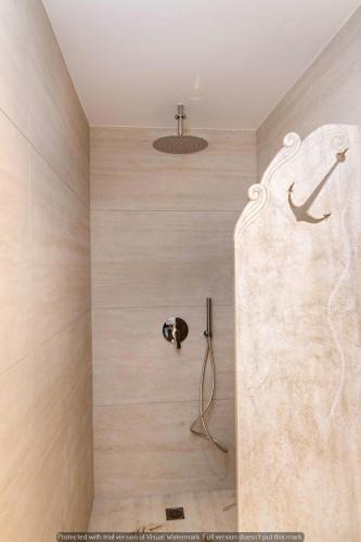a shower with a stone wall in a bathroom at Joyful Tinos in Tinos Town