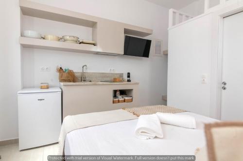 a white kitchen with a bed and a sink at Joyful Tinos in Tinos Town