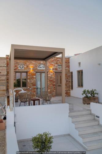 a patio with white stairs and a brick building at Joyful Tinos in Tinos Town