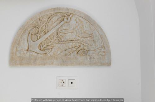 a wood carving of a bird and a branch at Joyful Tinos in Tinos Town