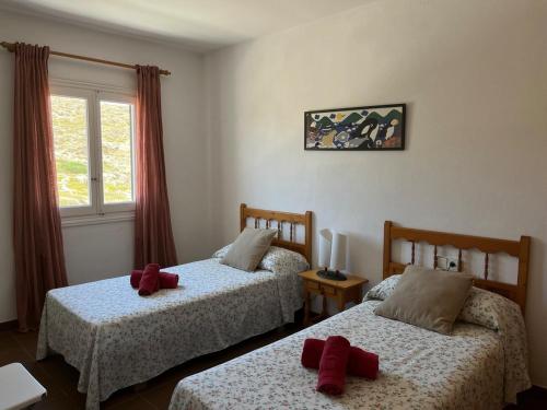 ein Schlafzimmer mit 2 Betten und roten Kissen darauf in der Unterkunft ES FAR AZUL by SOM Menorca in Fornells