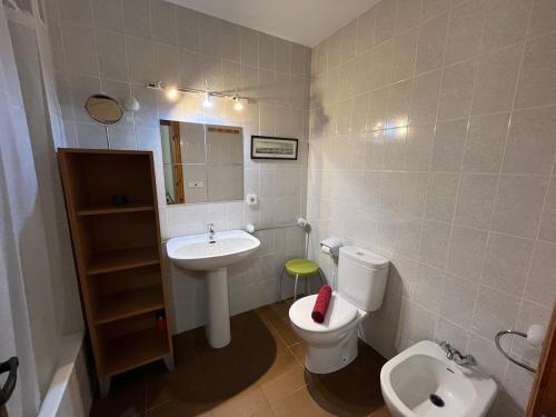 ein Badezimmer mit einer weißen Toilette und einem Waschbecken in der Unterkunft ES FAR AZUL by SOM Menorca in Fornells